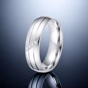 Detail of silver titanium ring with double grooves and three small inlaid diamonds