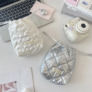 Close-up of heart-quilted white drawstring pouch and silver checkered storage bag