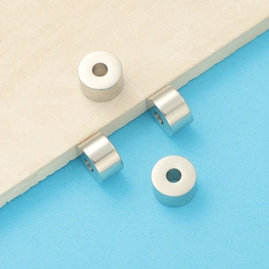 Polished metal cylindrical spacer beads for DIY jewelry making on a bicolor background