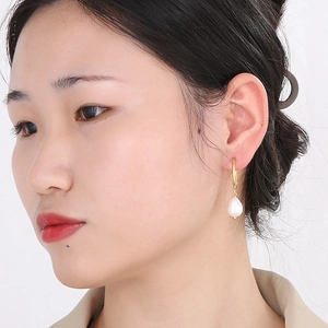 Gros plan d'une boucle d'oreille élégante en or 18K avec perle d'eau douce