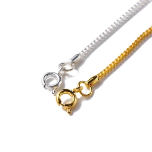 Close-up of gold and silver box chains with high-quality spring ring clasp detail