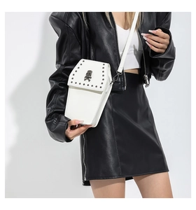 Détail du sac cercueil gothique blanc avec tête de mort et clous porté par le modèle