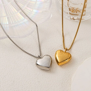 Detail of silver and gold heart necklaces with mon amour engraving on box chains