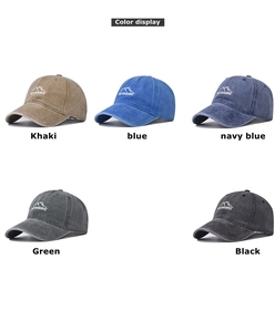 Macro detail of washed cotton baseball caps showing OUTDOORS embroidery and peak logo