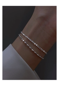 Close-up of elegant double-layered 925 silver plated bracelet on woman's wrist