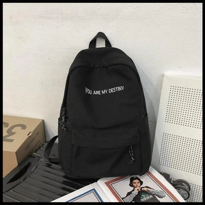 Gros plan du sac à dos noir avec texte brodé blanc et détails de style urbain moderne