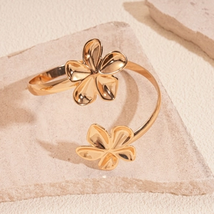 Detailaufnahme des goldenen floralen Armreifs mit polierter metallischer Oberfläche