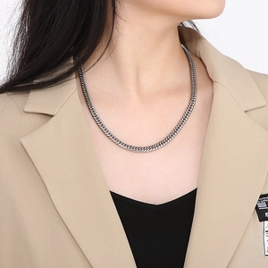 Close-up of high-polished silver curb chain necklace worn by a male model in streetwear style