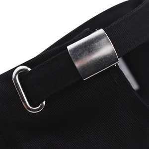 Detailed macro view of adjustable silver buckle and metal grommet on black cotton baseball cap