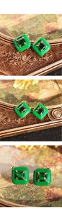 Close-up of vintage square stud earrings featuring green enamel and emerald zircon stones