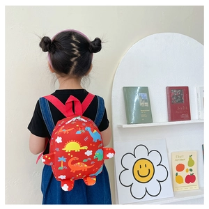 Toddler backpack with colorful dinosaur print shown on child's back in a bright room