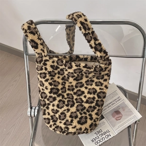 Detailed texture of a leopard print plush fleece tote bag on a minimalist chair