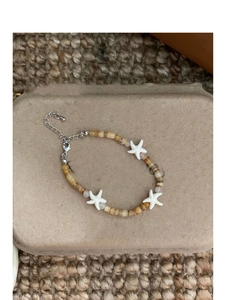 Close-up of brown and white beaded bracelet with starfish charms on display card