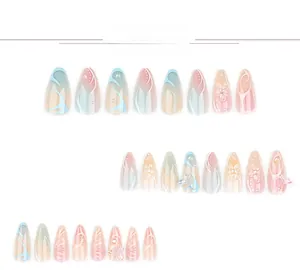 Detailed view of almond press-on nails with 3D butterflies, pearls and floral designs