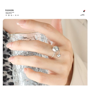 Détail d'une bague ajustable en argent avec billes métalliques portée par un mannequin