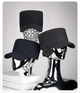 Detail view of winter woolen flat caps with ear protection and metal SPORT badge