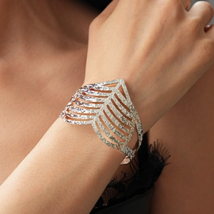 Detail of silver hollowed wide cuff bracelet with textured hammered finish on a model