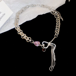 Detailed shot of silver chain necklace featuring purple heart gem and rhinestone tassels