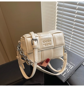 Détail du sac à bandoulière tissé crème avec breloque étoile et chaîne en métal