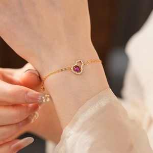Makro-Detail des 18K vergoldeten Hula-Armbands mit lila Edelstein und weißen Zirkonia-Steinen