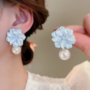 Detail view and model shot of blue resin flower earrings with white pearl pendants