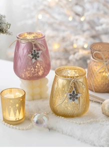 Detail of mercury glass Christmas candle holders with wooden star charms and warm LED lighting