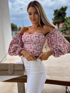 Detail of floral off-shoulder top with smocked bodice and elegant puff sleeves