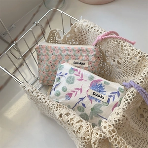 Dettaglio di borse per trucco in cotone e lino a fiori con cerniera e cordini