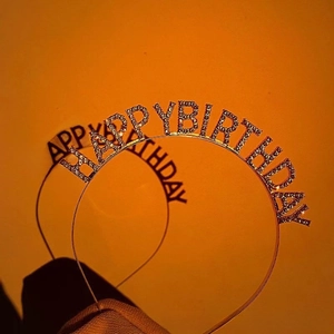 Detail showing the shiny rhinestone HAPPY BIRTHDAY lettering on the metal headbands