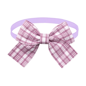 Detail of purple plaid pet bowtie accessory with elastic band and premium fabric texture