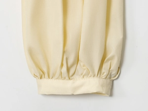 Detailed close-up of cream yellow poplin shirt cuffs with pleats and fine stitching