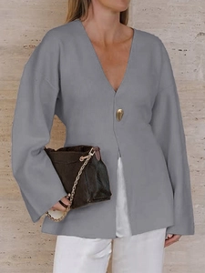 Detailed view of gray V-neck long sleeve top featuring a single gold button accent