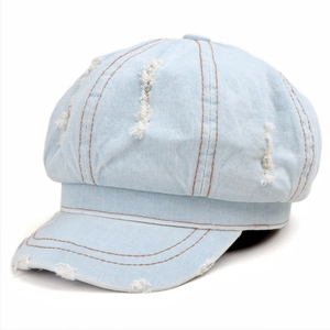 Distressed light blue denim newsboy cap with vintage frayed edges and contrast stitching
