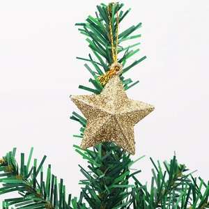 Sparkling gold star Christmas tree ornament with glitter finish on a green pine branch