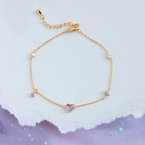 Elegant gold chain bracelet featuring a pink heart zircon and purple floral accents