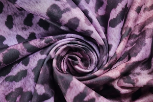 Detail of purple leopard print fabric swirled into a floral shape with soft shadows