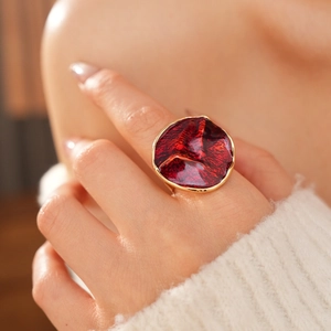 Close-up of a vintage red enamel gold ring worn by a model in a luxury jewelry set