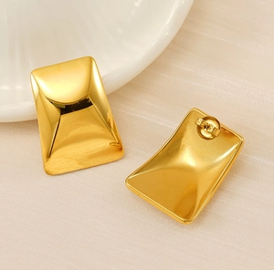 Détail de boucles d'oreilles dorées rectangulaires concaves de style géométrique chic