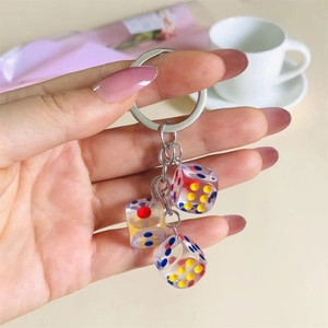 Close-up of resin dice keychain with red, yellow, and blue dots on a metallic chain