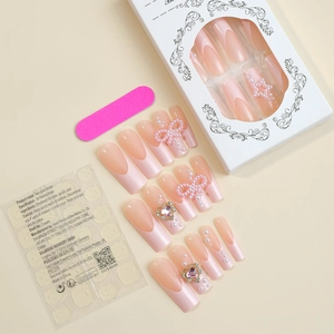 Detail view of XXL long French press-on nails with pearl bows and heart gems set