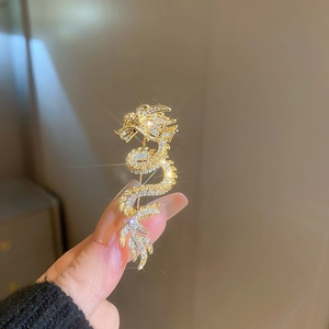 Macro shot of 14k gold-plated dragon brooch inlaid with sparkling white zircons