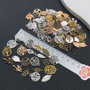 Mixed tree of life charms and leaf pendants in various colors with measurement ruler