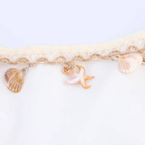 Bohemian beach dress with seashell and starfish chain details in a solid cream color