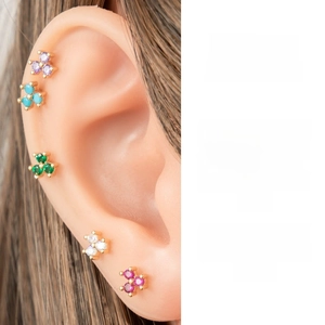 Detail of floral zircon stud earrings in various colors with golden claw setting