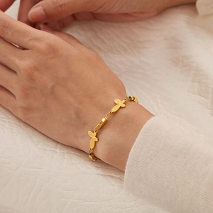 Détail du charm papillon doré et des perles carrées sur un bracelet élégant pour femme