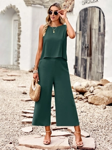 Detail of dark green sleeveless crop top and linen wide-leg pants on female model
