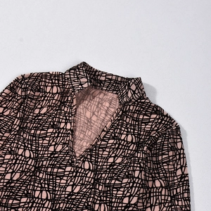 Close-up of pink and black geometric pattern crop top with V-neckline detail