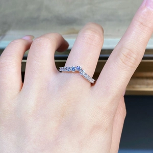 Gros plan d'une bague en argent en forme de V sertie de diamants sur le doigt