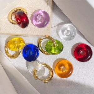Polished gold earrings with colorful resin donut pendants in various vibrant shades