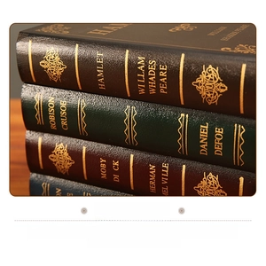 Close-up of vintage faux book storage boxes with embossed leather texture and gold detailing